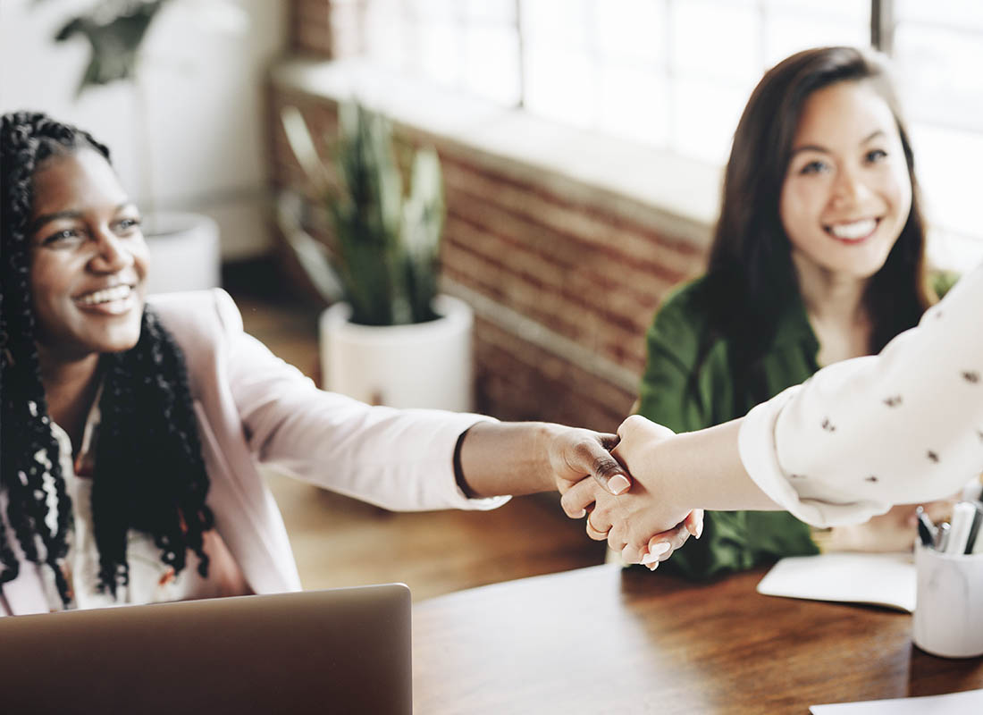 Refer a Friend - Two Business Women in an Insurance Meeting Discussing New Business